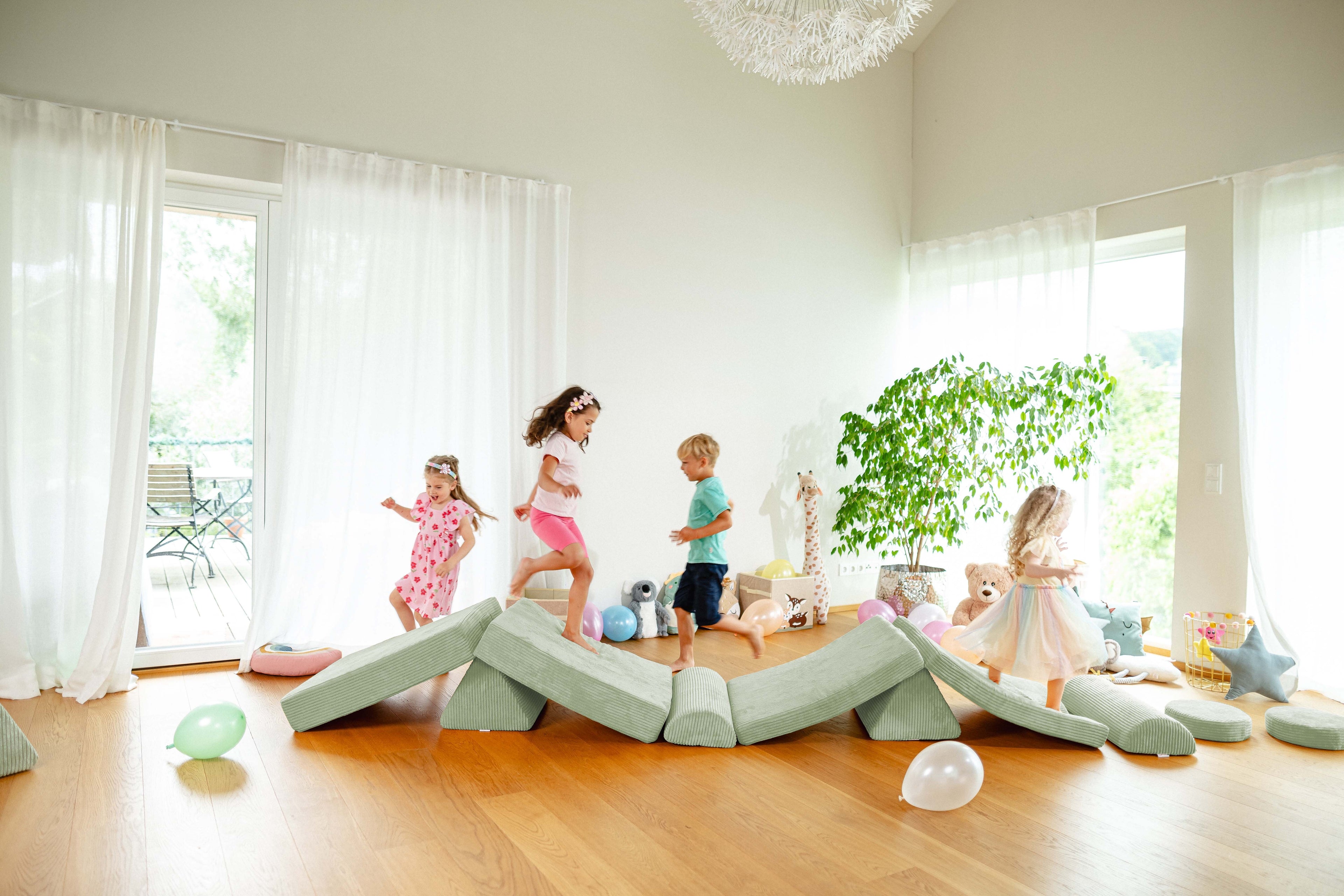 Kinder klettern und balancieren auf einem Linolino Spielsofa in Avocado Grün