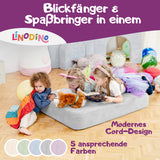 Spielmatte in Grau, genutzt als Hüpfpolster und Lesefläche für Kinder